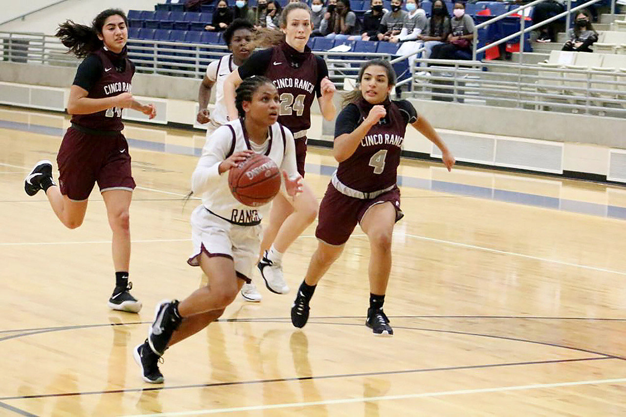 George Ranch junior guard Savannah Velazquez runs past a trio of Cinco Ranch defenders in Thursday's 6A bi-district playoff game at Hopson Field House.
