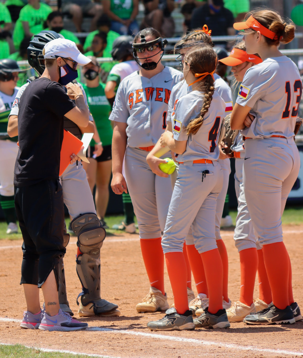 Seven Lakes softball coach Katie Spencer, left in black, talks to her players during a District 19-6A playoff play-in game against Mayde Creek on Saturday, April 24, at Morton Ranch High.