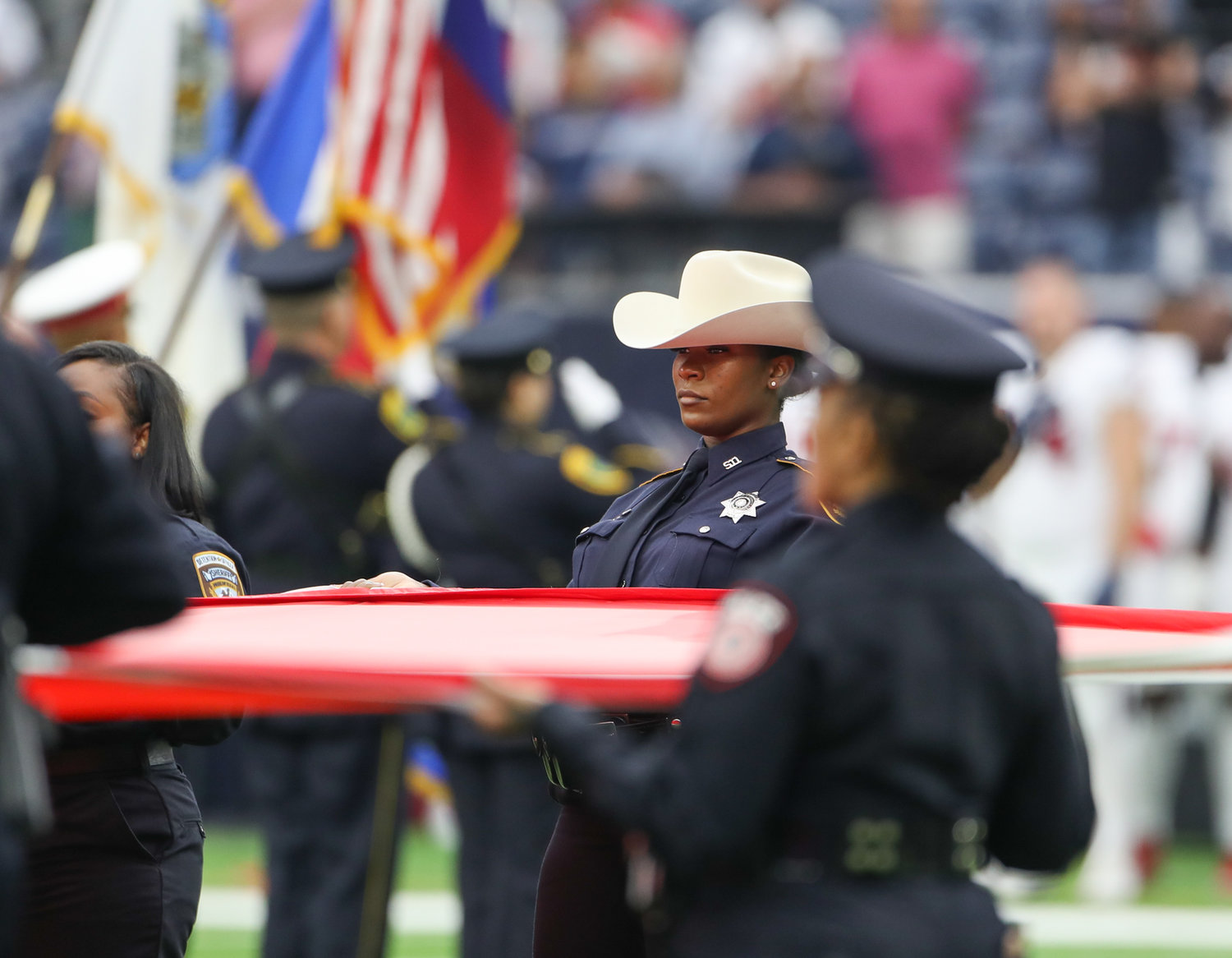 Law enforcement officers and first responders from the Houston metro area hold a flag during the national anthem before the start of an NFL game between the Houston Texans and the Jacksonville Jaguars on September 12, 2021 in Houston, Texas.