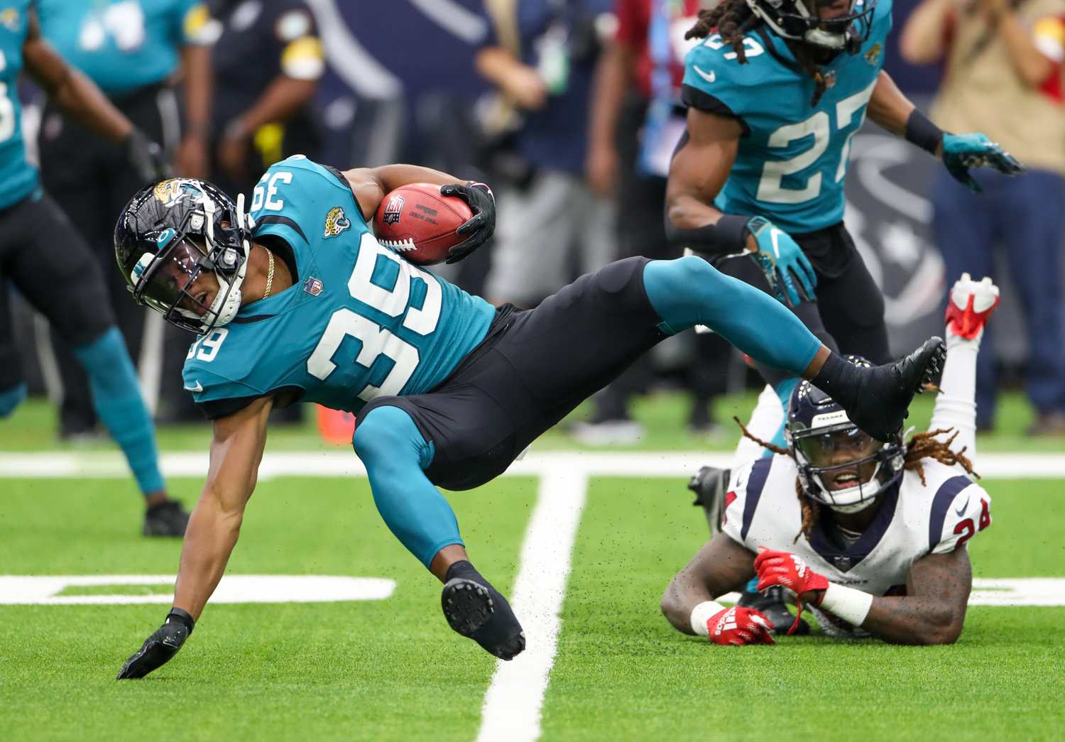 Houston Texans defensive back Tremon Smith (24) trips up Jacksonville Jaguars wide receiver Jamal Agnew (39) during the first half of an NFL game between the Houston Texans and the Jacksonville Jaguars on September 12, 2021 in Houston, Texas.