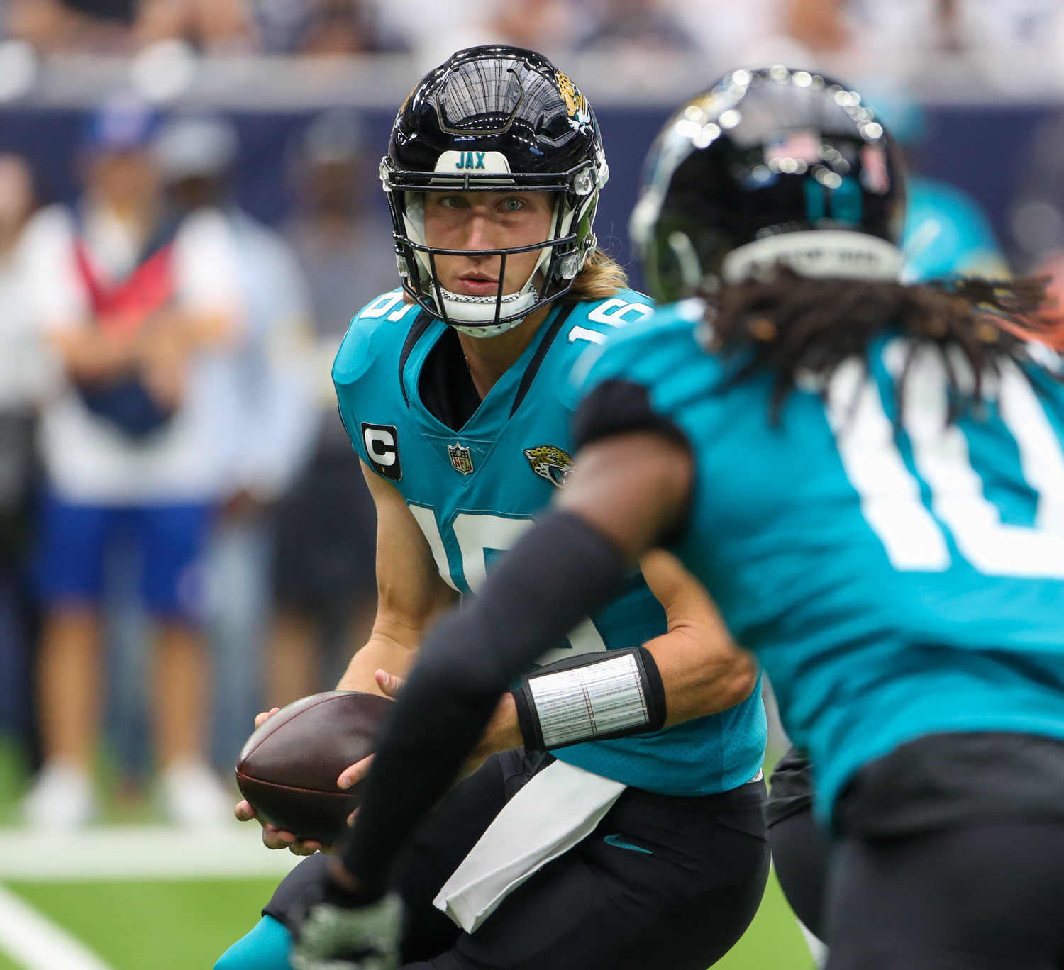Jacksonville Jaguars quarterback Trevor Lawrence (16) prepares to hand the ball to wide receiver Laviska Shenault Jr. (10) on a reverse during the first half of an NFL game between the Houston Texans and the Jacksonville Jaguars on September 12, 2021 in Houston, Texas.