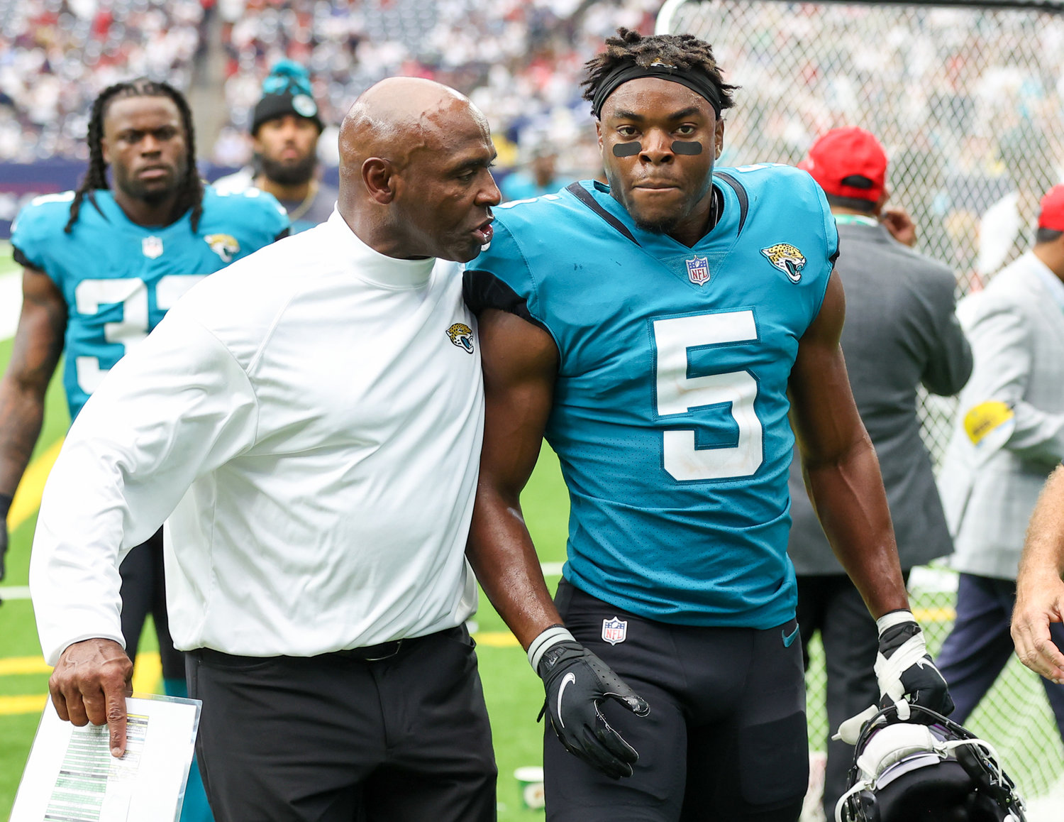 Jacksonville Jaguars associate head coach Charlie Strong talks with defensive back Rudy Ford (5) as the team heads to the locker room at halftime during an NFL game between the Houston Texans and the Jacksonville Jaguars on September 12, 2021 in Houston, Texas.