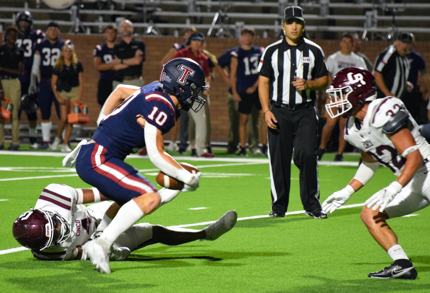 Tompkins’ Wyatt Young tries to break away from Cinco Ranch defenders during a District 19-6A game at Rhodes Stadium on Thursday.