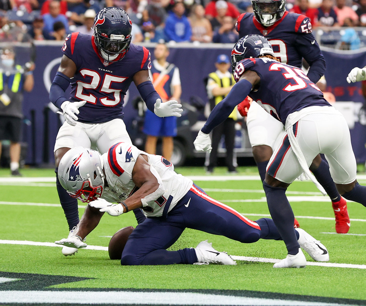 New England Patriots running back Damien Harris (37) loses the ball just before crossing the goal line, with game officials ruling on video review that Houston Texans cornerback Terrance Mitchell (39) punched the ball out to force a fumble before a touchdown during an NFL game between Houston and New England on October 10, 2021 in Houston, Texas. The Patriots won 25-22.