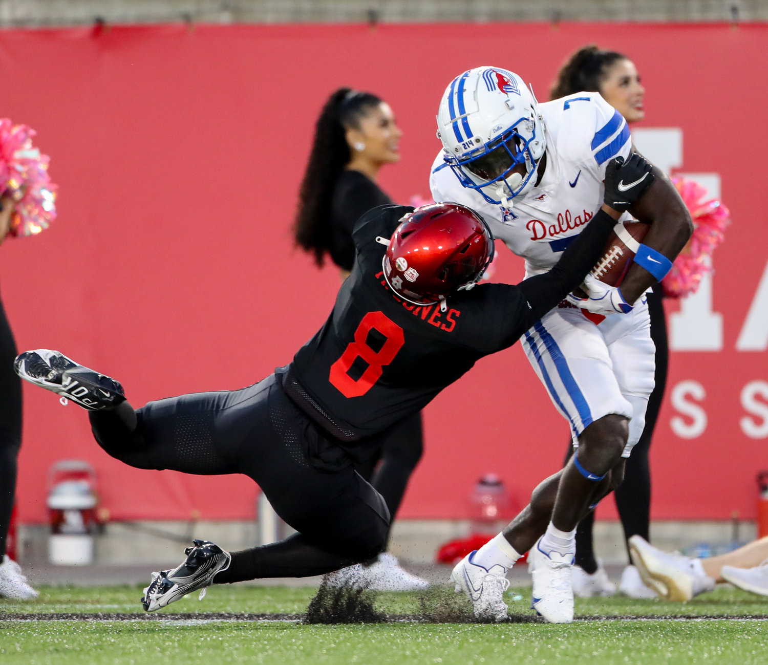 Houston Cougars cornerback Marcus Jones (8) brings down SMU Mustangs running back Ulysses Bentley IV (7) after a catch during an NCAA football game between Houston and SMU on October 30, 2021 in Houston, Texas.