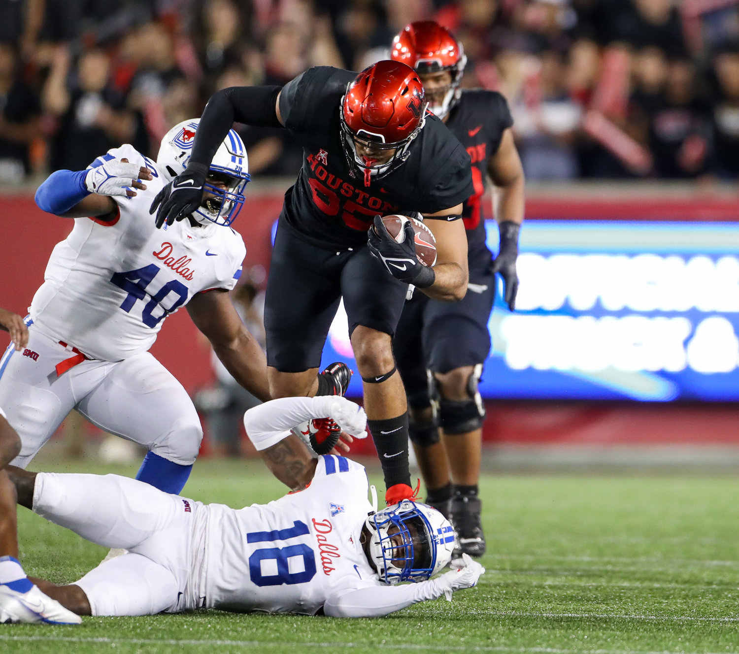 Houston Cougars tight end Christian Trahan (85) steps over SMU Mustangs safety Chace Cromartie (18) on a carry during an NCAA football game between Houston and SMU on October 30, 2021 in Houston, Texas.