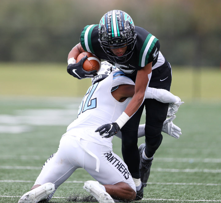Cedar Park Timberwolves senior wide receiver Nicholas Grullon (5) is tackled by Paetow Panthers senior defensive back Michael Jordan (12) after a catch during a high school football playoff game between Cedar Park and Paetow on November 26, 2021 in Waller, Texas.