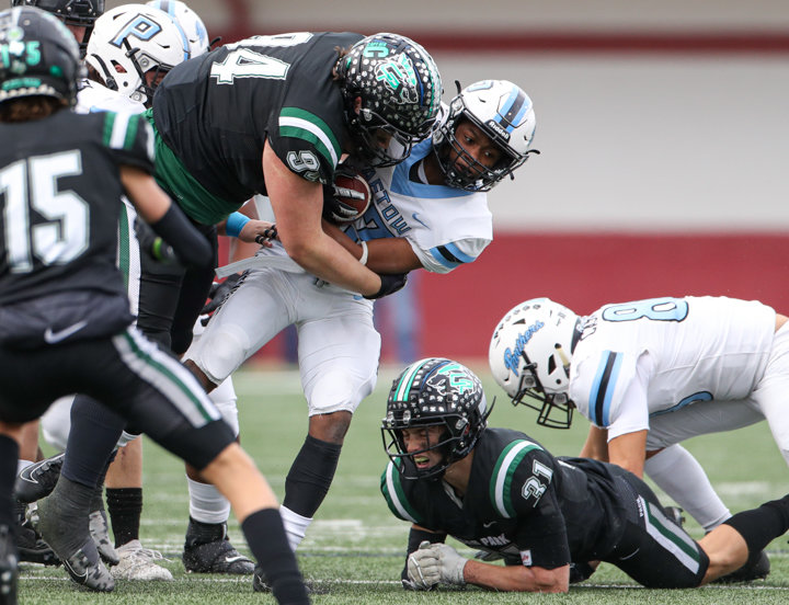 Cedar Park Timberwolves senior defensive lineman Murray Robinson (94) tackles Paetow Panthers sophomore running back Jamaal Comminie (23) during a high school football playoff game between Cedar Park and Paetow on November 26, 2021 in Waller, Texas.