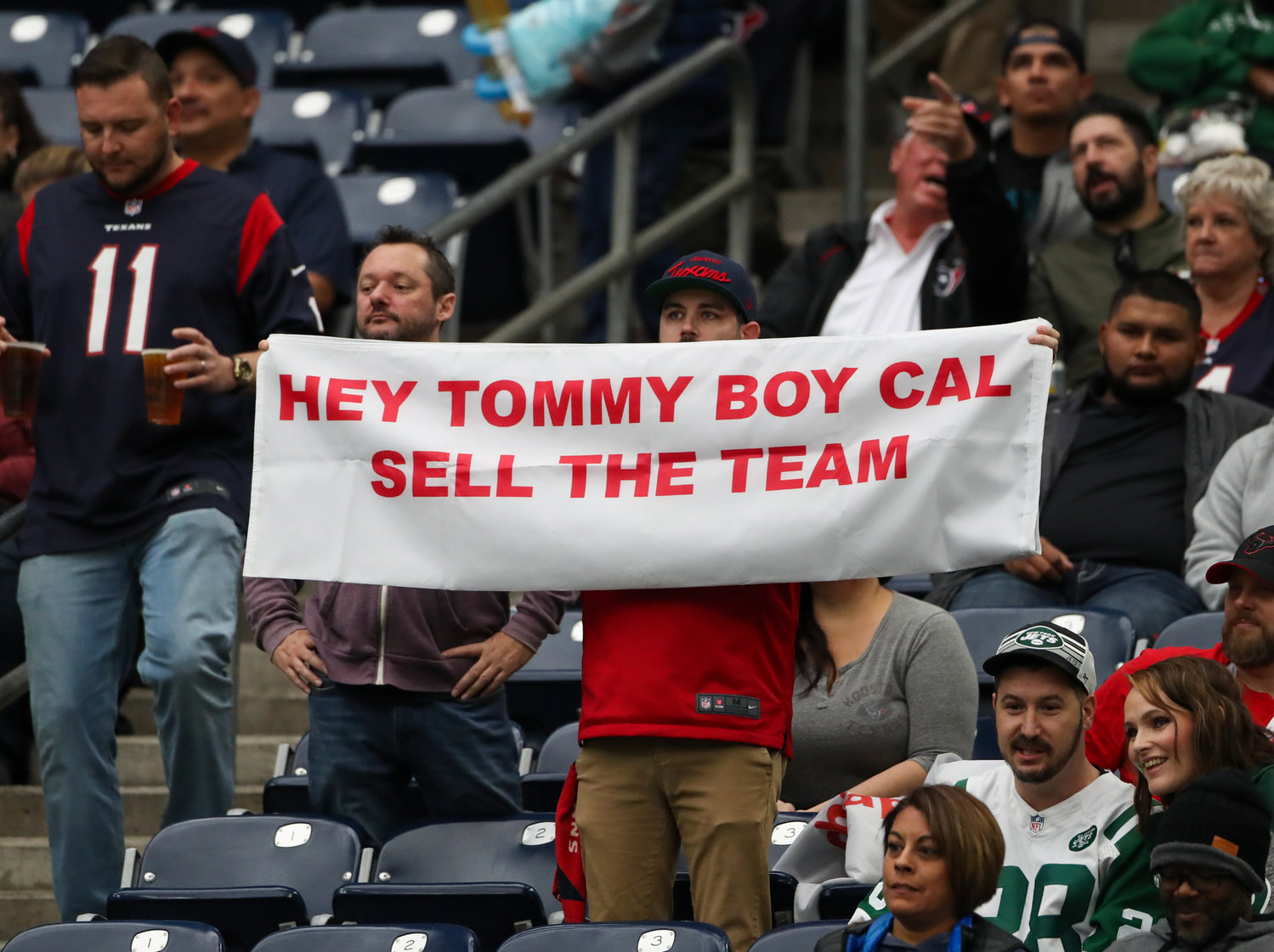 A Houston Texans fan holds up a sign about Houston Texans Chairman and Chief Executive Officer Cal McNair during an NFL game between the Houston Texans and the New York Jets on November 28, 2021 in Houston, Texas. The Jets won, 21-14