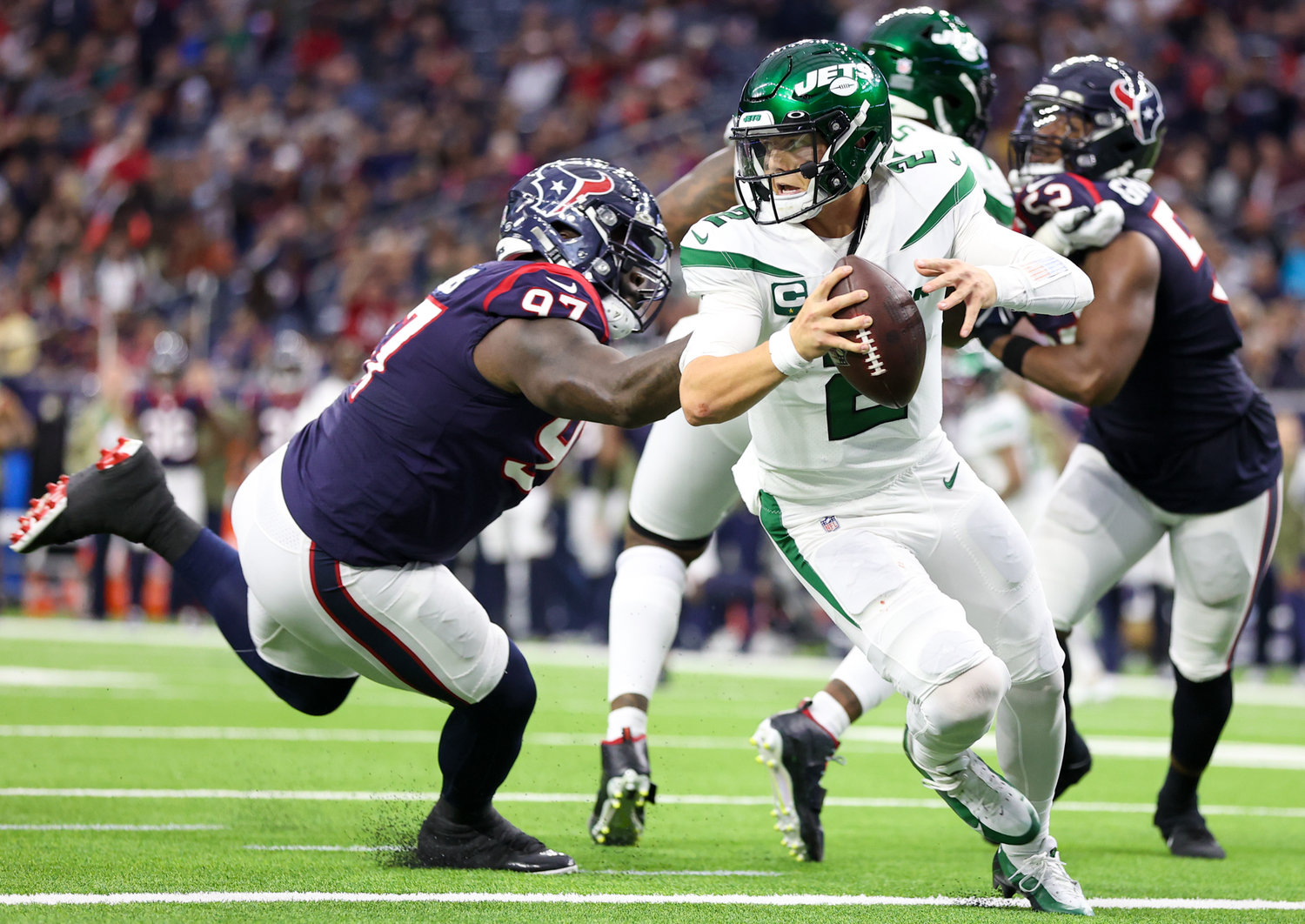 New York Jets quarterback Zach Wilson (2) eludes Houston Texans defensive tackle Maliek Collins (97) to avoid a sack during an NFL game between the Houston Texans and the New York Jets on November 28, 2021 in Houston, Texas. The Jets won, 21-14