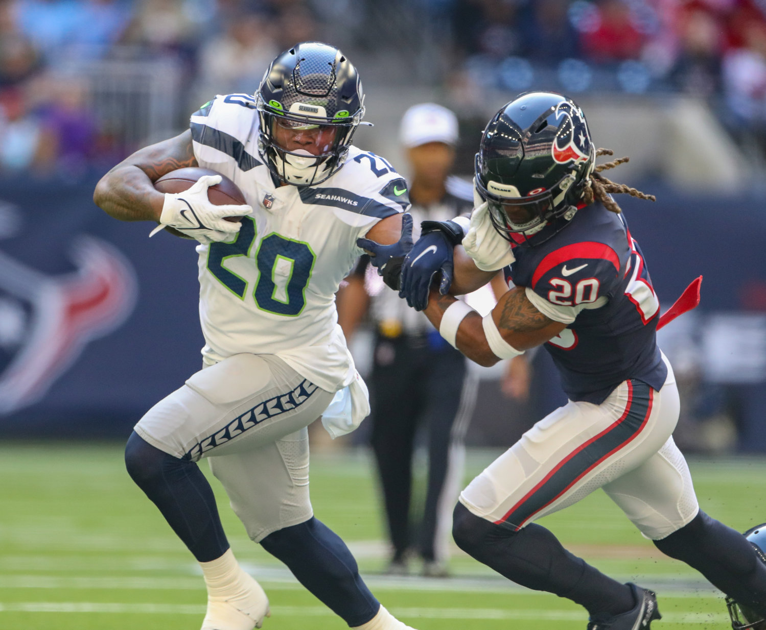 Seattle Seahawks running back Rashaad Penny (20) runs past Houston Texans safety Justin Reid (20) during the first half of an NFL game between the Seahawks and the Texans on December 12, 2021 in Houston, Texas.