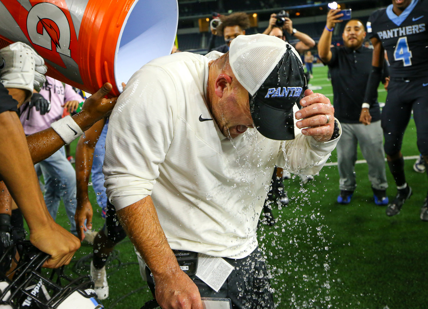 Players empty the water cooler on Paetow Panthers head coach B.J. Gotte after a 27-24 overtime win over College Station in the Class Class 5A Division I state football championship game on December 17, 2021 in Arlington, Texas.