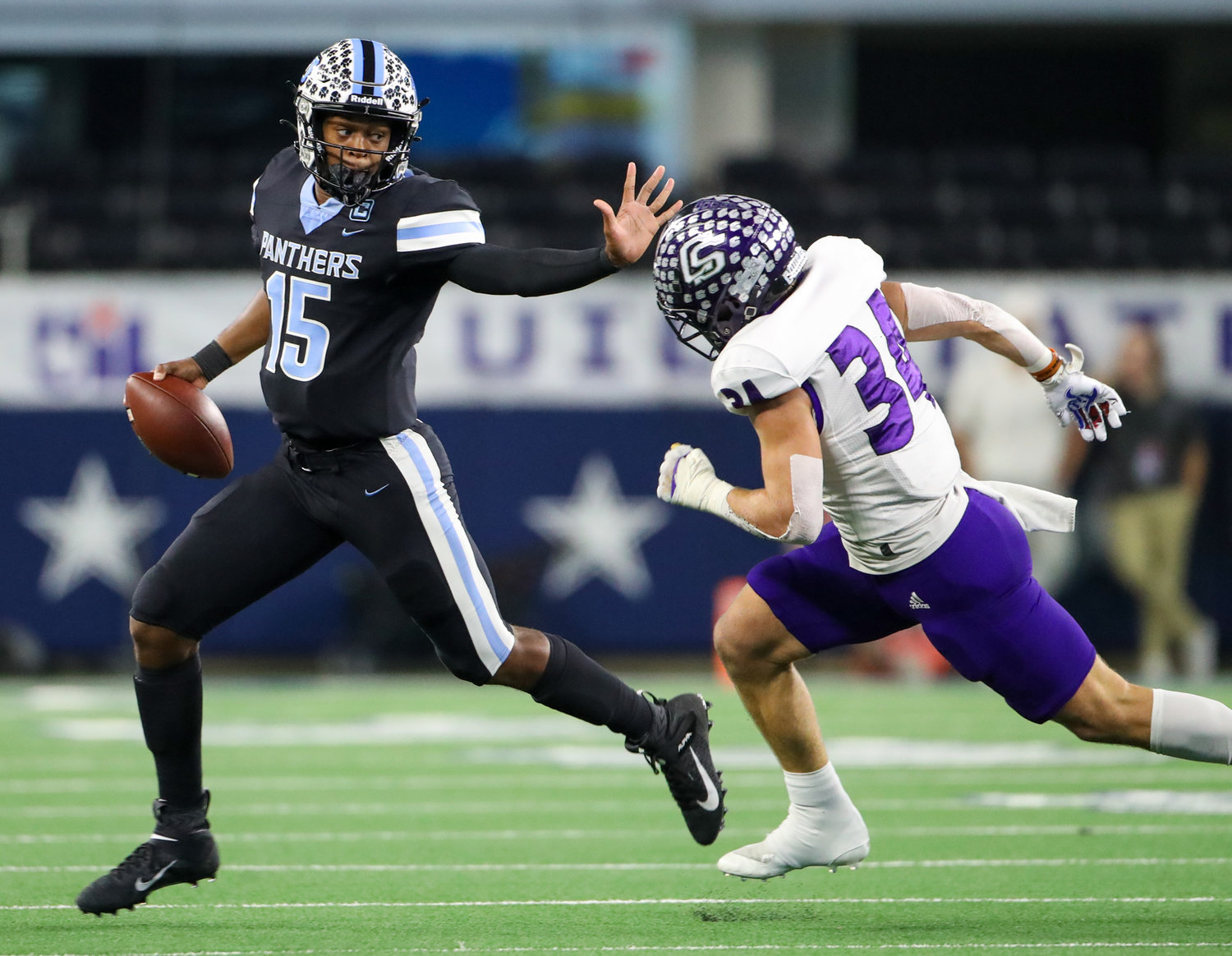 Paetow Panthers quarterback C.J. Dumas Jr.  (15) delvers a stiff arm to College Station Cougars linebacker Jaxson Slanker (34) on a carry during the Class 5A-Division I state football championship game between Paetow and College Station on December 17, 2021 in Arlington, Texas.