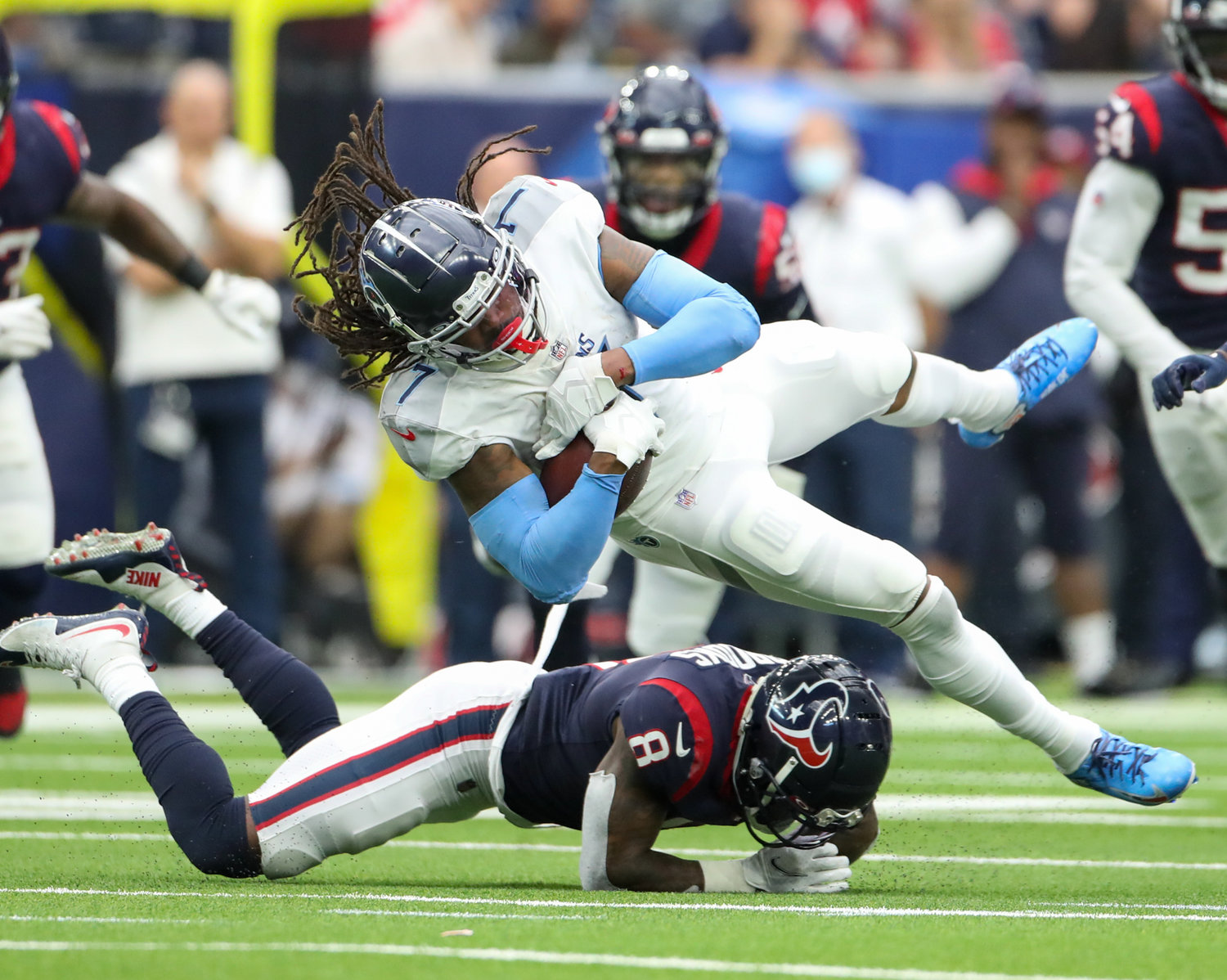 Tennessee Titans running back D'Onta Foreman (7) is tripped up by Houston Texans free safety Terrence Brooks (8) during an NFL game on Jan. 9, 2022 in Houston, Texas.