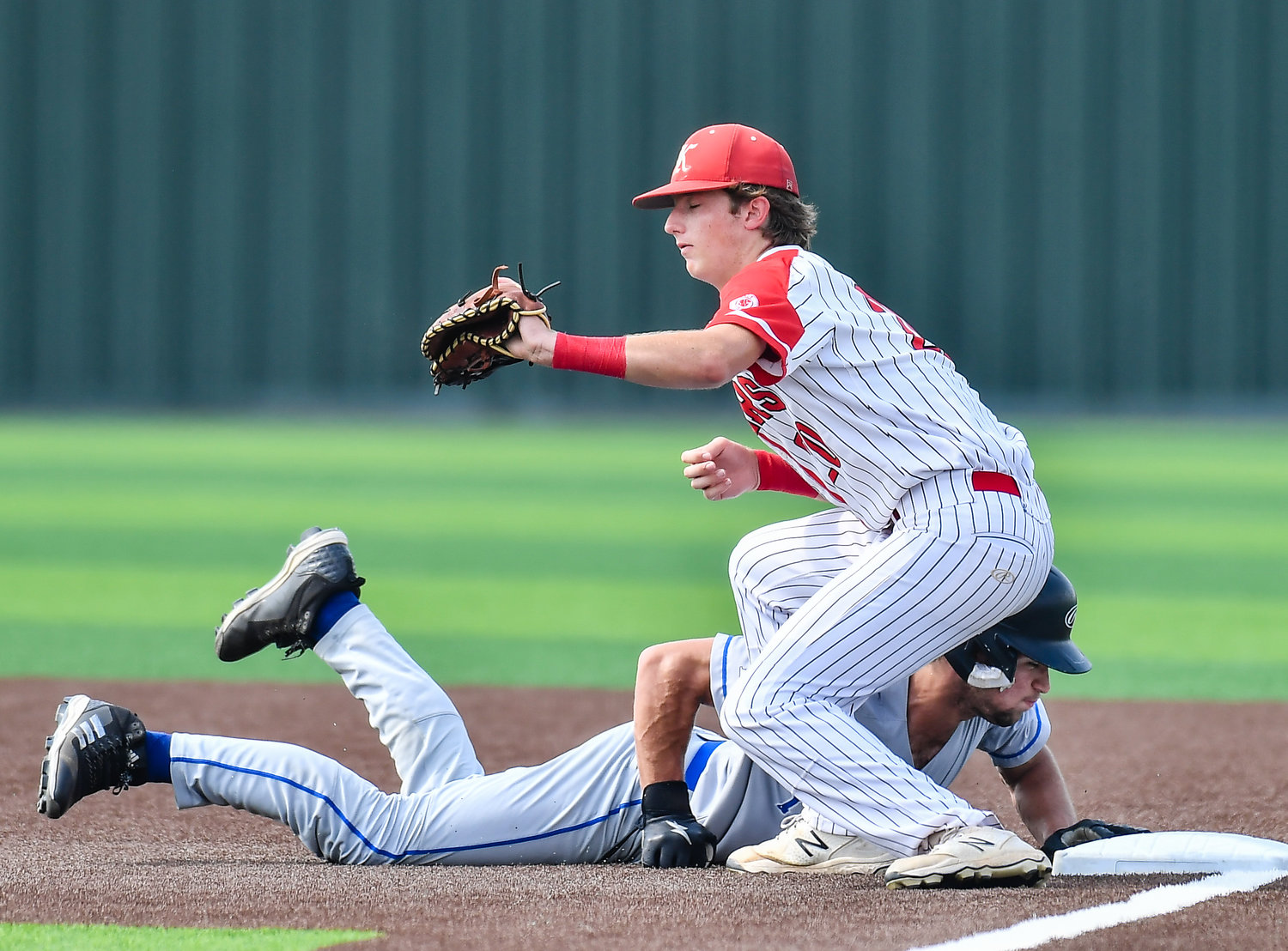 Katy Taylor's Yianni Stellakis (11) gets back to first avoiding the tag by Katy's Sutton Hull (20) during the second inning in a Region III-6A quarterfinals baseball game at Langham Creek High School, Saturday, May 21, 2022.
