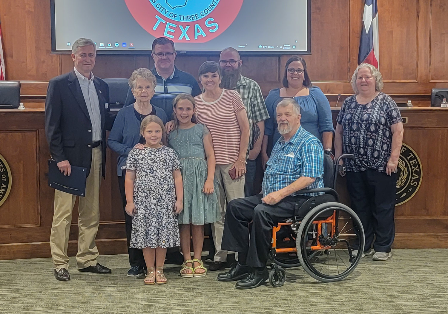 Mickie Christy stands with Mayor Dusty Thiele, left, and her family as she is honored Monday at City Hall.