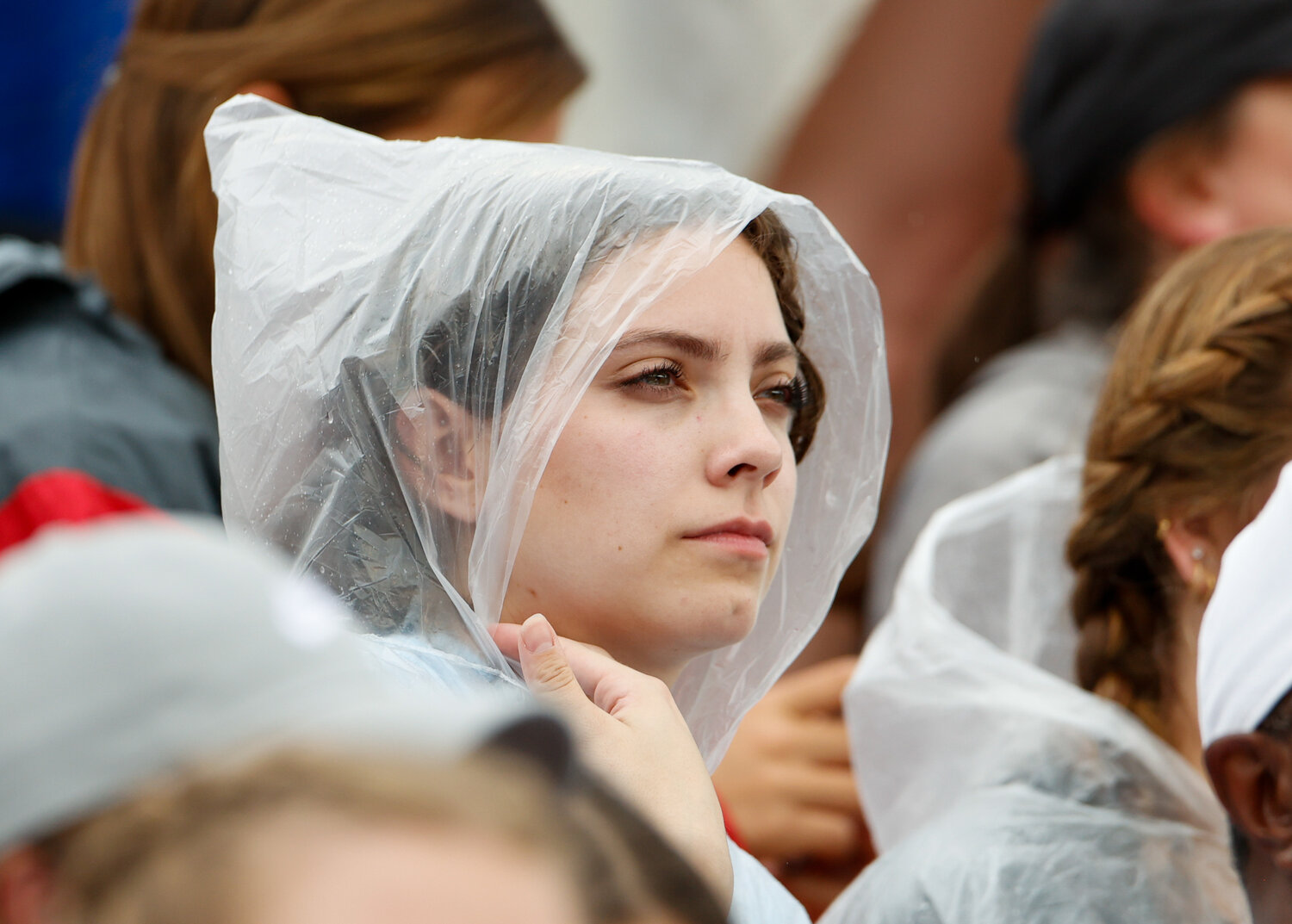 Fans watch the running events through intermittent rain showers during the UIL State Track and Field Meet on Saturday, May 13, 2023 in Austin.