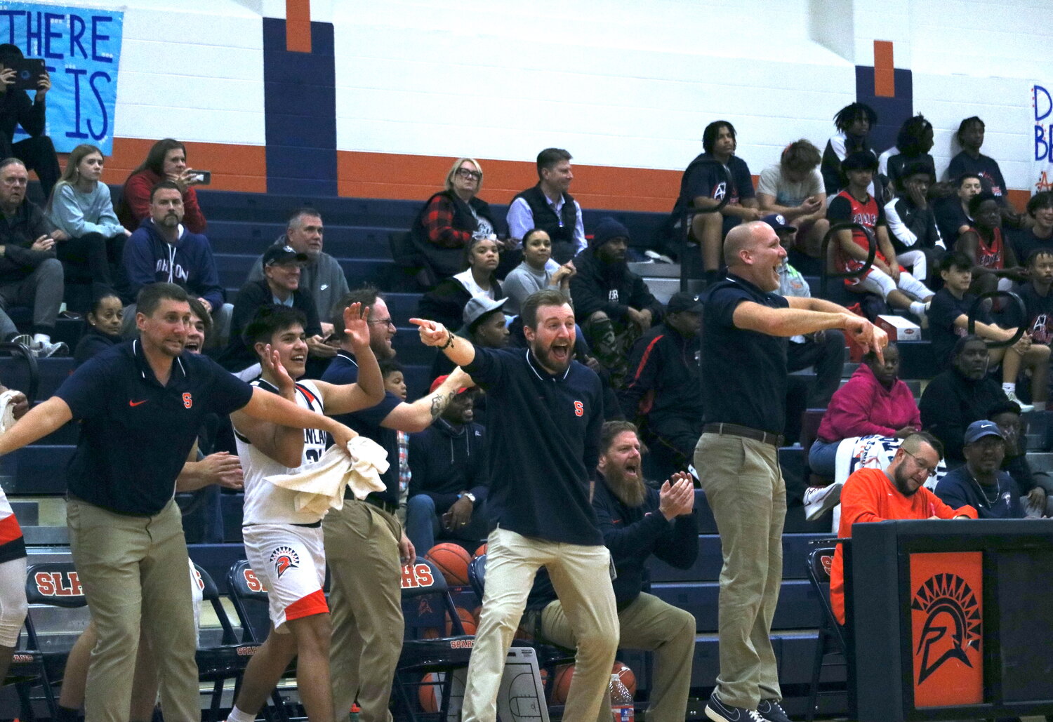 Seven Lakes coaches celebrate after a dunk by Brett Norton during Monday's game between Seven Lakes and Pearland Dawson at the Seven Lakes gym.