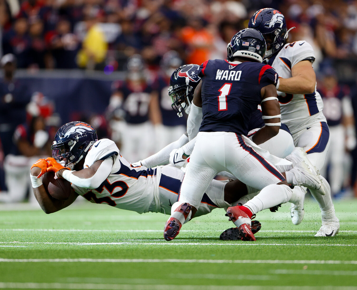 Broncos running back Javonte Williams (33) dives forward to pick up a first down during an NFL game between the Texans and the Broncos on December 3, 2023 in Houston. The Texans won, 22-17.