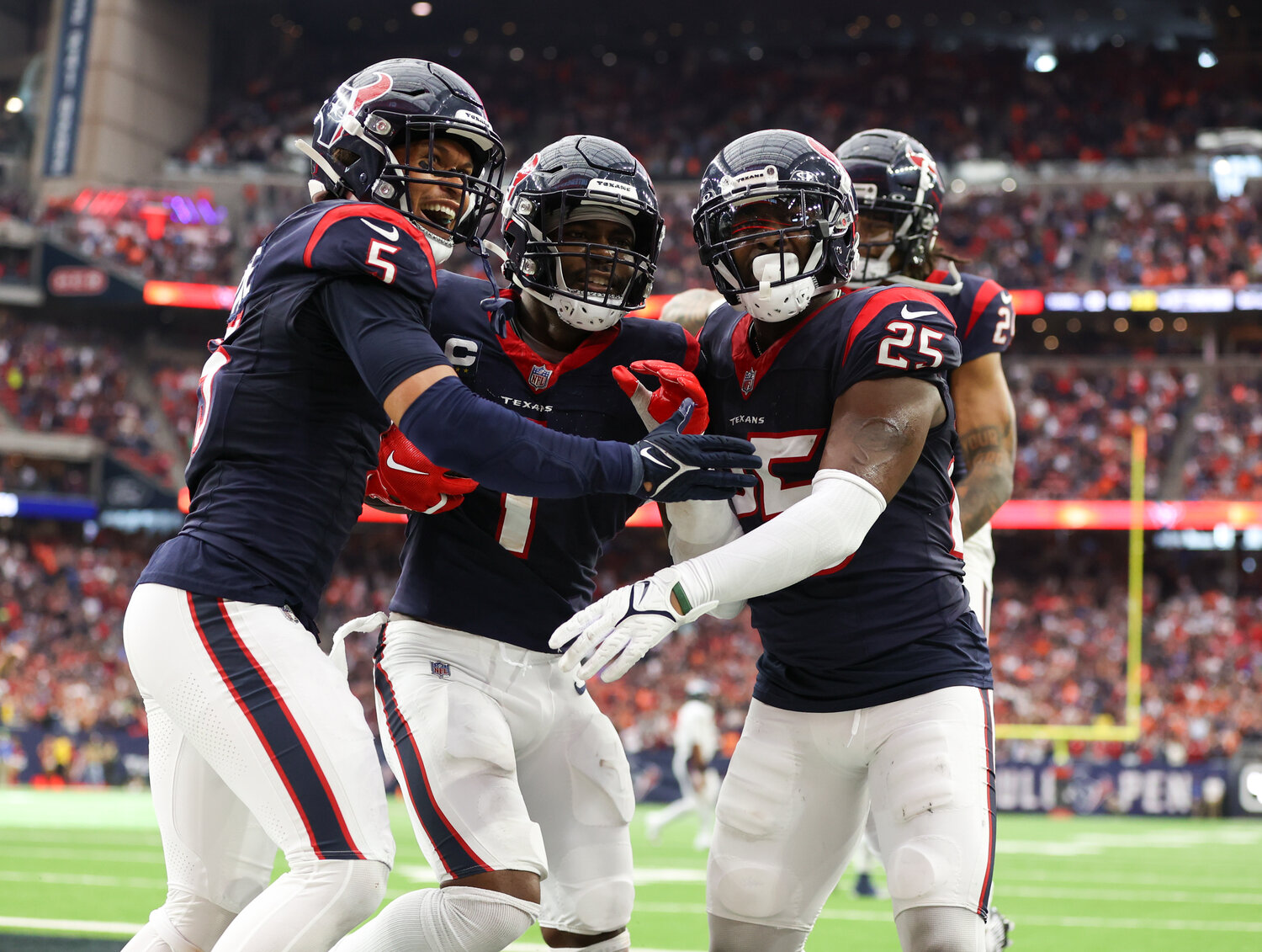 Texans safety Jalen Pitre (5) and cornerback Desmond King II (25) celebrate with safety Jimmie Ward (1) after Ward made an interception in the end zone in the final seconds of the game to secure a 22-17 win over the Broncos in an NFL game on December 3, 2023 in Houston.
