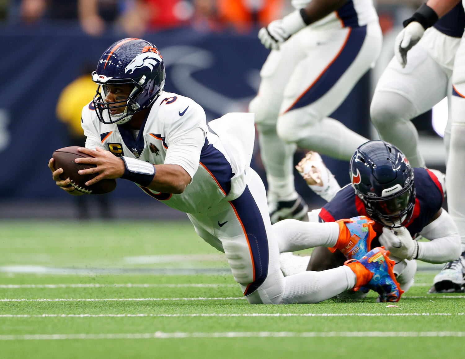 Broncos quarterback Russell Wilson (3) dives forward for a first down during an NFL game between the Texans and the Broncos on December 3, 2023 in Houston. The Texans won, 22-17.