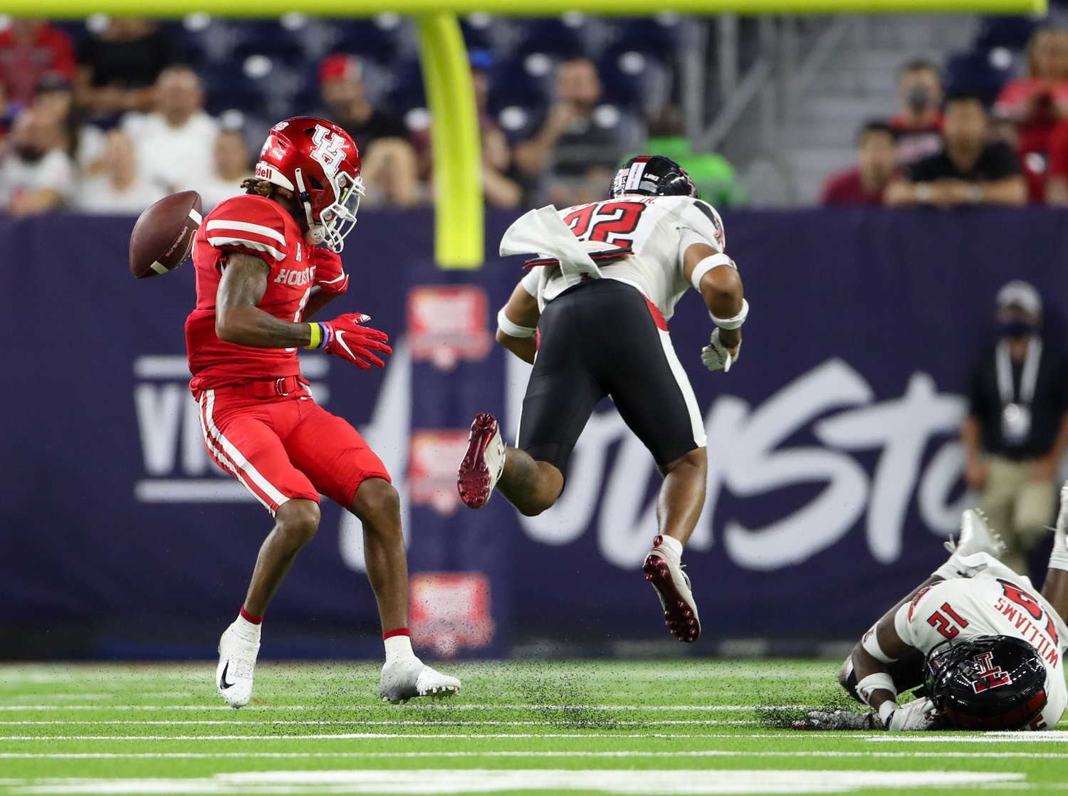 Texas Tech Red Raiders defensive back Reggie Pearson Jr. (22) causes a fumble with a hit on Houston Cougars wide receiver Nathaniel Dell (1) during an NCAA football game between Houston and Texas Tech on September 4, 2021 in Houston, Texas.
