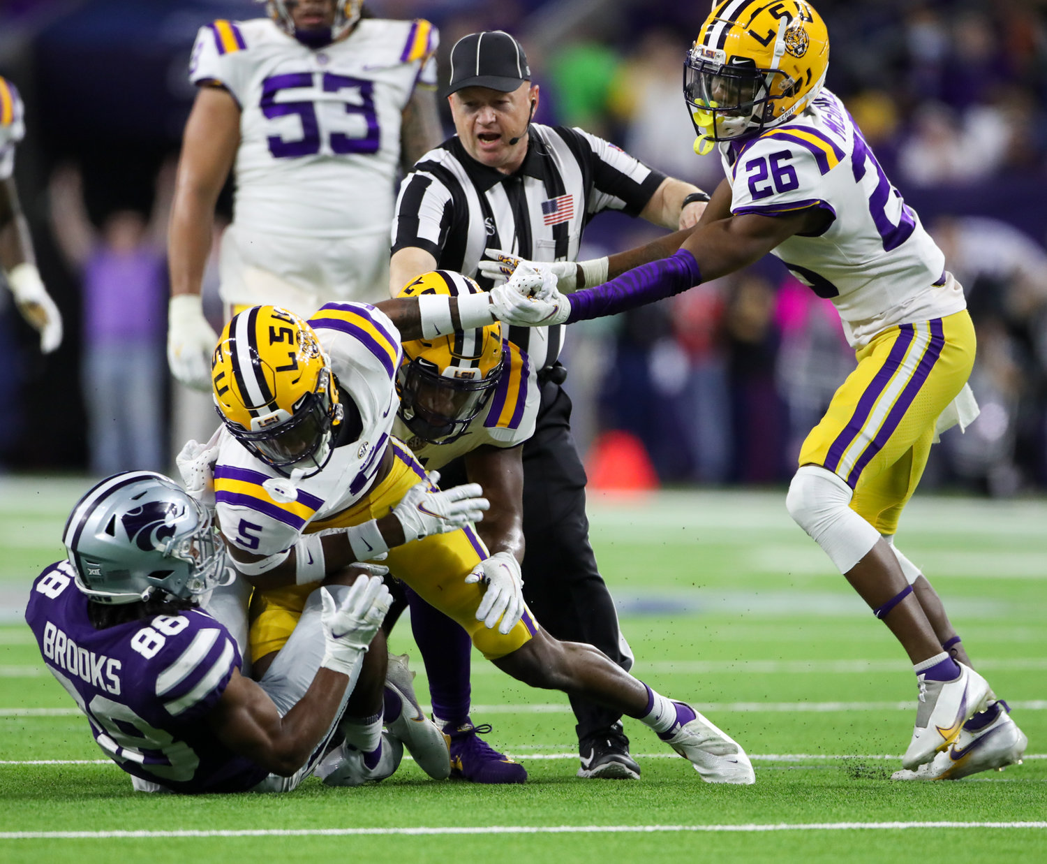 LSU Tigers defensive back Damarius McGhee (26) and umpire Tim Gover work to break up a scuffle between Tigers safety Jay Ward (5) and Kansas State Wildcats wide receiver Phillip Brooks (88) during the first half of the TaxAct Texas Bowl on Jan. 4, 2022 in Houston, Texas.