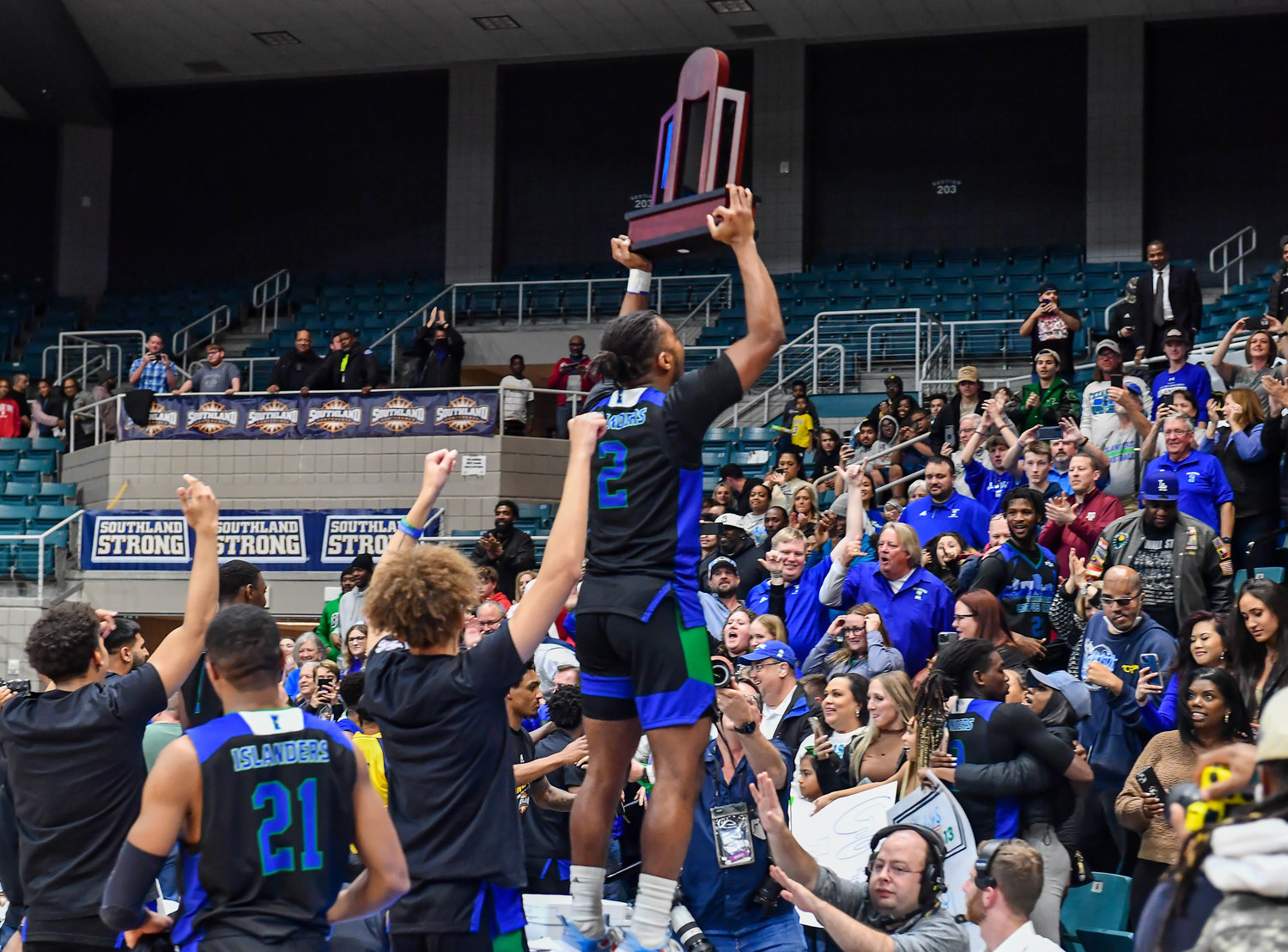 March 12, 2022:  A&M-Corpus Christis Myles Smith #2 holds up the trophy to the crowd after winning the Southland Conference Basketball Championship game between A&M Corpus Christi vs Southeastern Louisiana. (Photo by Mark Goodman / Katy Times)