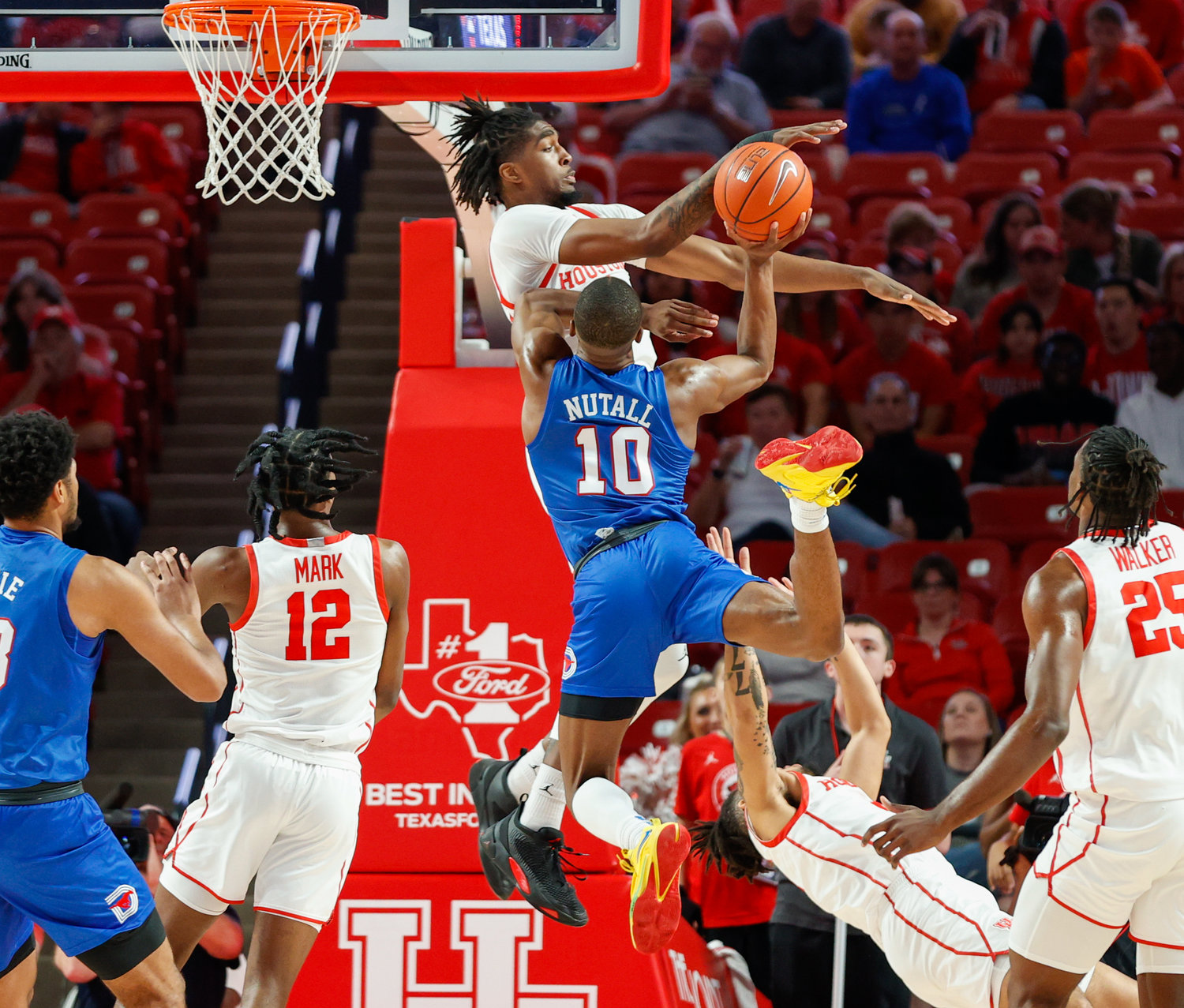 Houston forward Ja'Vier Francis (5) blocks a shot by SMU guard Zach Nutall (10) during an NCAA men’s basketball game between the Houston Cougars and the Southern Methodist Mustangs on Jan. 5, 2023 in Houston. Houston won, 87-53,