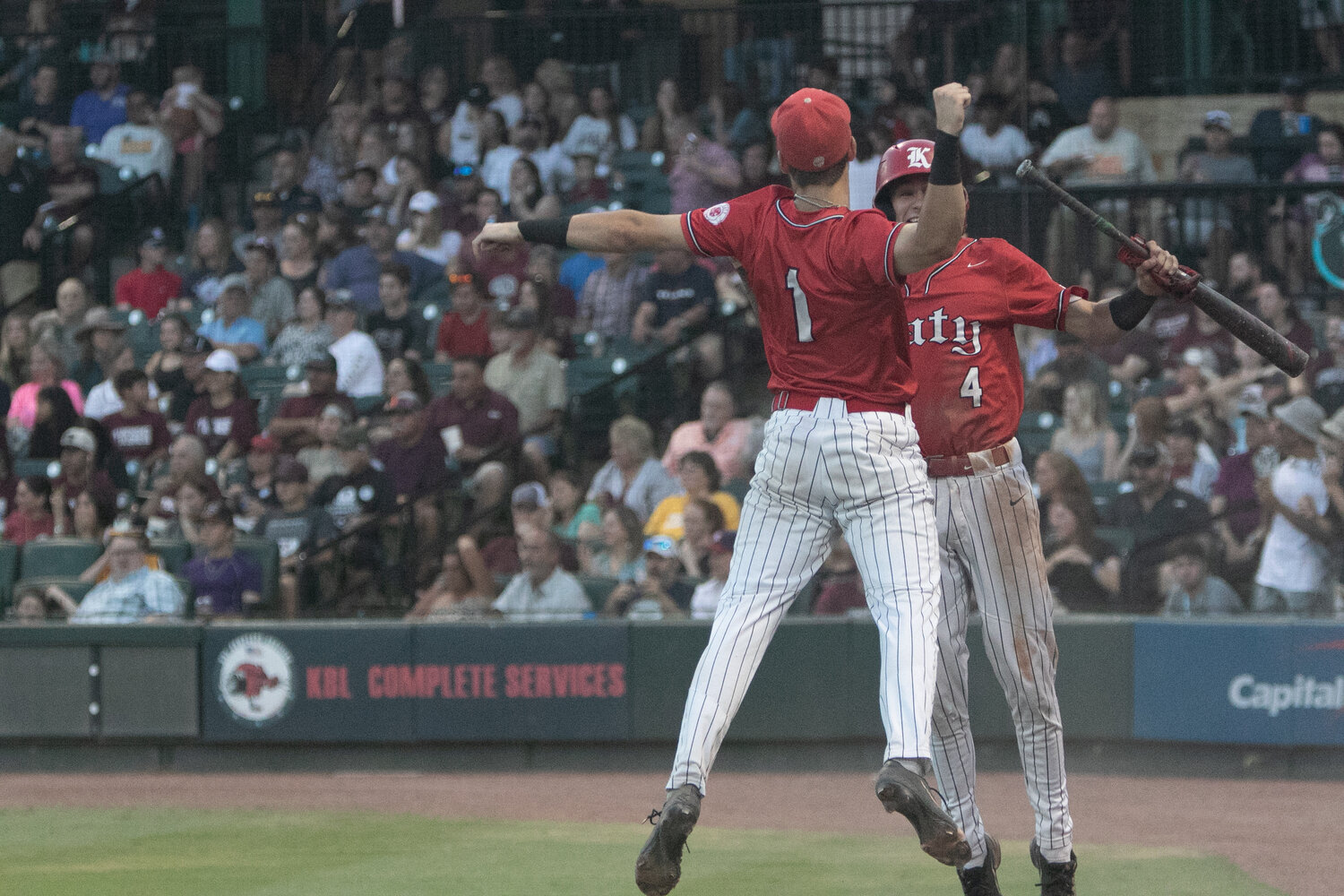 Andrew Horner and Graham Laxton celebrate after Horner scored a run during Friday's Regional Final between Katy and Pearland at Constellation Field in Sugar Land.