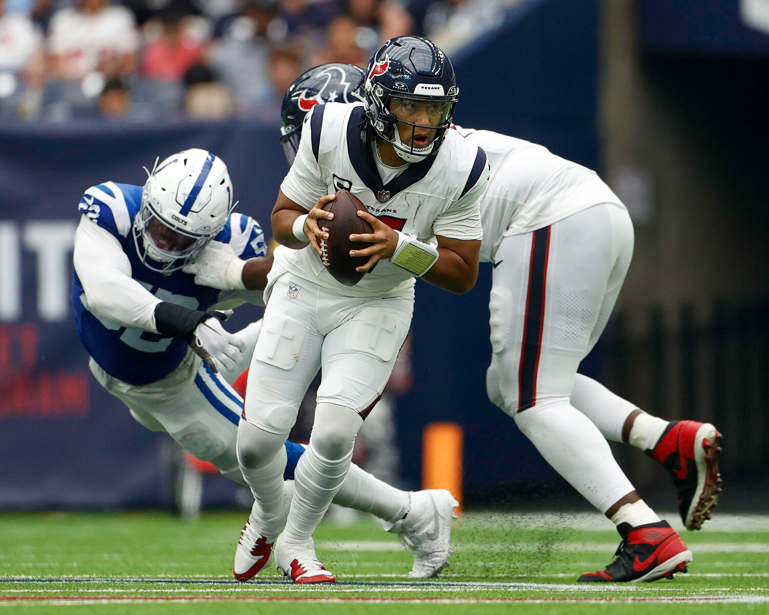 Texans quarterback C.J. Stroud (7) works to escape pressure as Colts defensive end Samson Ebukam (52) is blocked behind him during an NFL game between the Texans and the Colts on September 17, 2023 in Houston. The Colts won, 31-20.